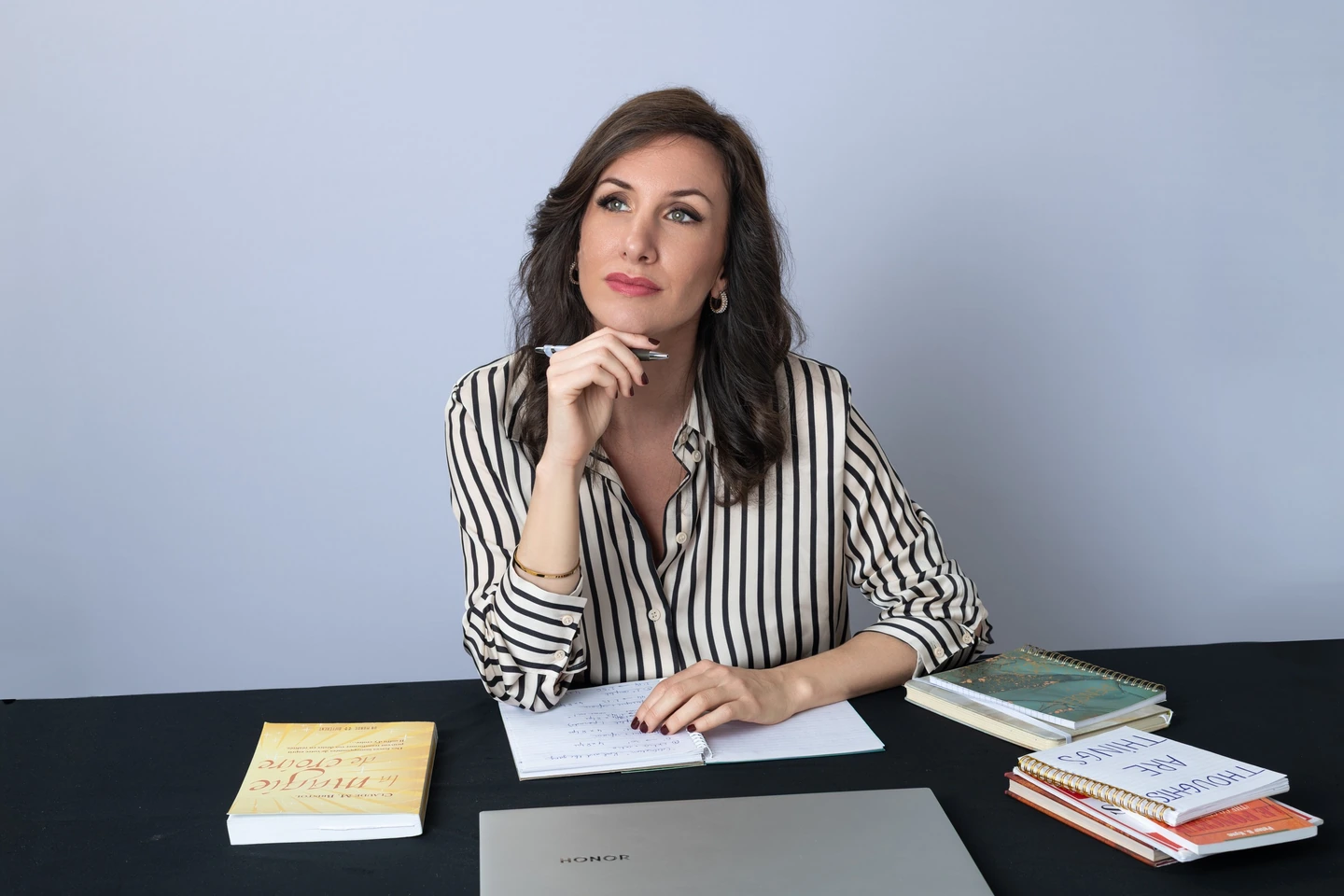 Charlotte Garaialde à son bureau, entourée de ses livres et de ses créations.